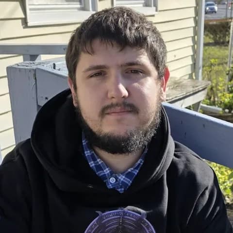Julian Shelton, sitting on a porch in a black hoodie